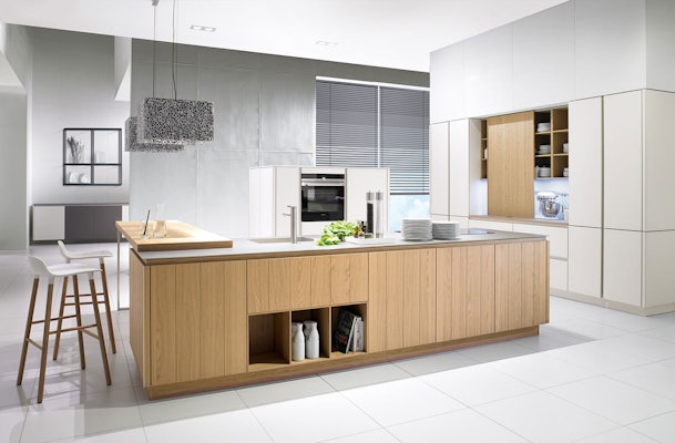 Strakke greeploze keuken met een houten eiland.